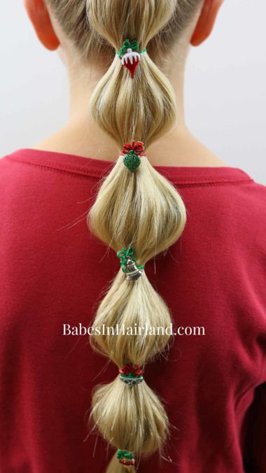 Make a fun bubble ponytail for Christmas with some cute holiday buttons. Try this cute hairstyle out for Christmas this year from BabesInHairland.com #hair #hairstyle #bubbleponytail #Christmas #Christmashairstyle #easyhairstyle #cute #ponytail