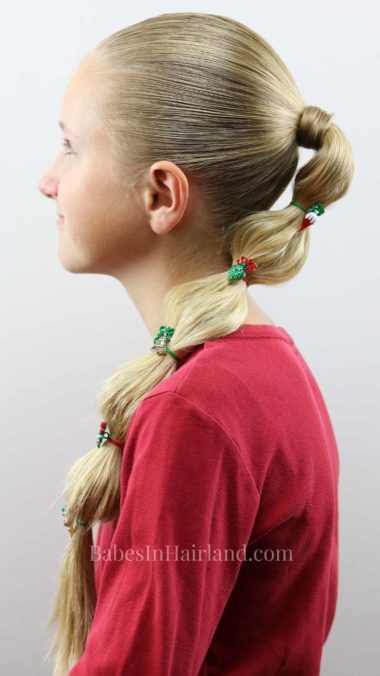 Make a fun bubble ponytail for Christmas with some cute holiday buttons. Try this cute hairstyle out for Christmas this year from BabesInHairland.com #hair #hairstyle #bubbleponytail #Christmas #Christmashairstyle #easyhairstyle #cute #ponytail